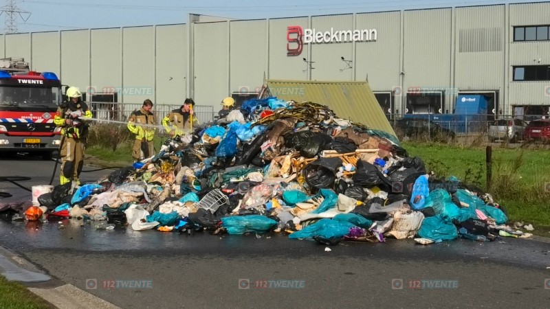 Brand in vuilniswagen in Enschede inhoud op straat
