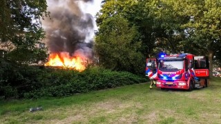 Uitslaande brand achter woning in Enschede