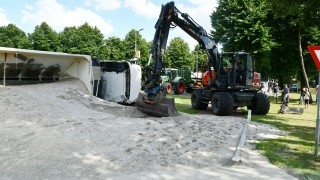 Vrachtwagen met zand kantelt op rotonde in Westerhaar